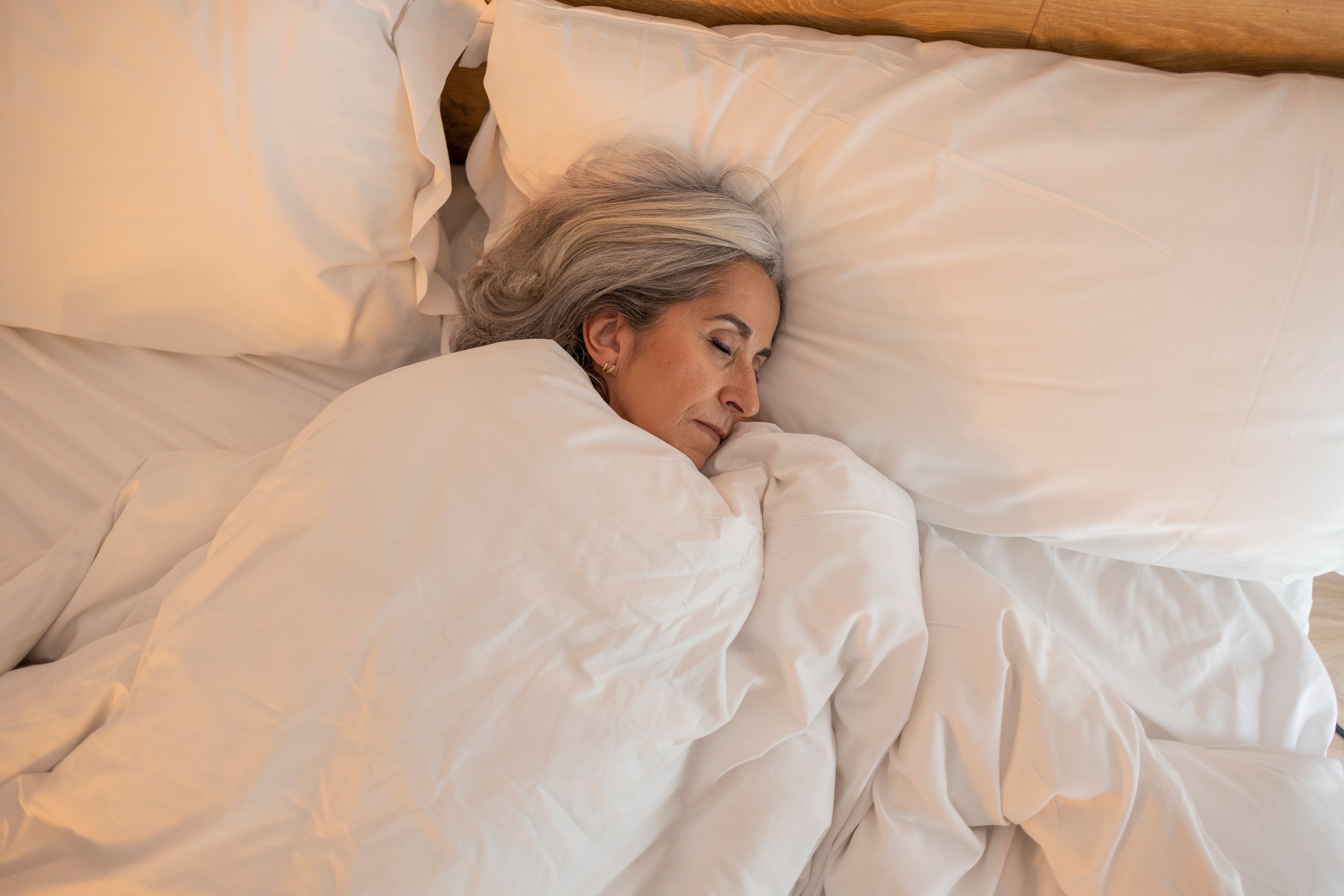 Eldre kvinne som sover i sengen